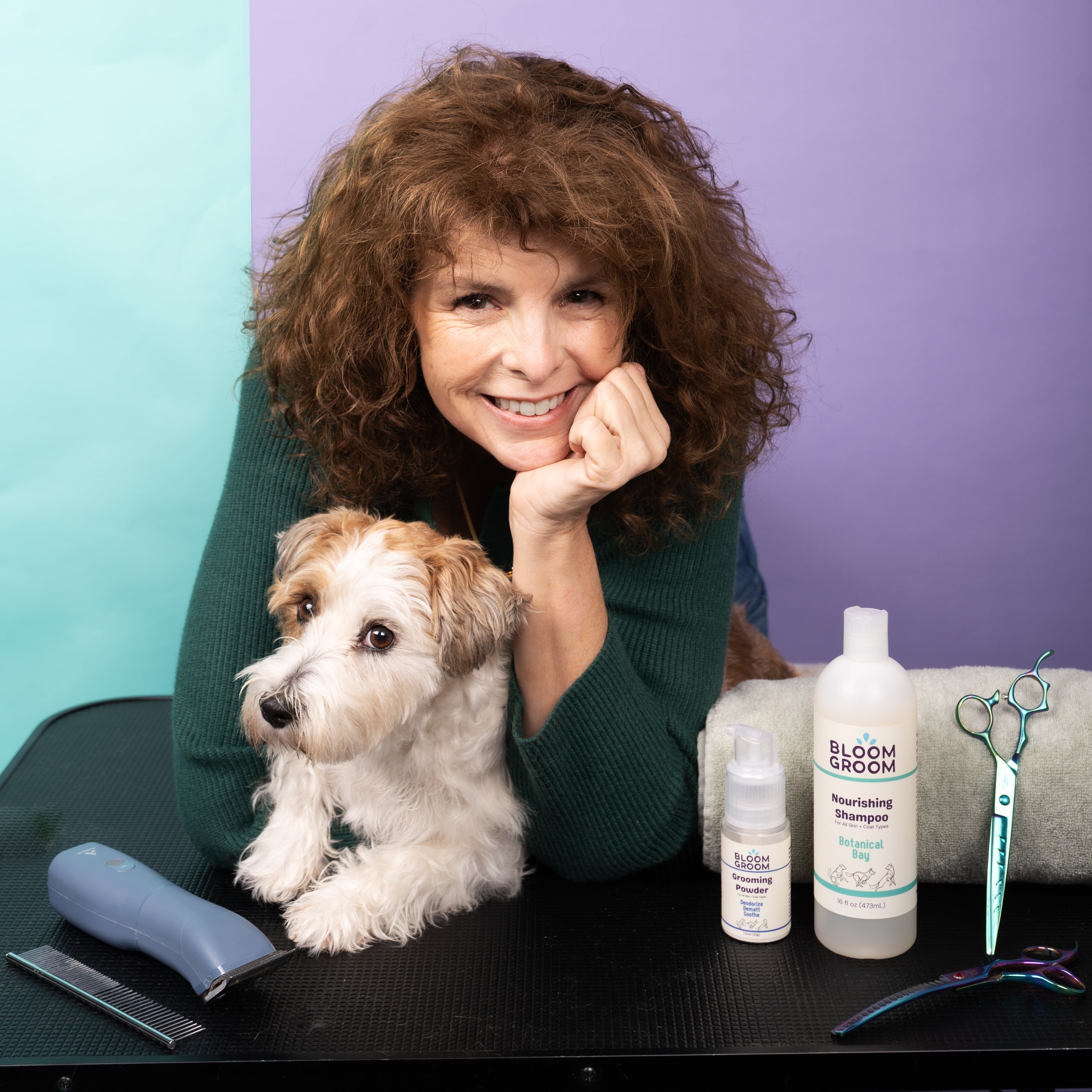 Woman with a dog and pet care products on a table against a colorful background